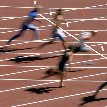 Mehrere Menschen rennen und verschwimmen dabei auf einem typisch roten Feld.
