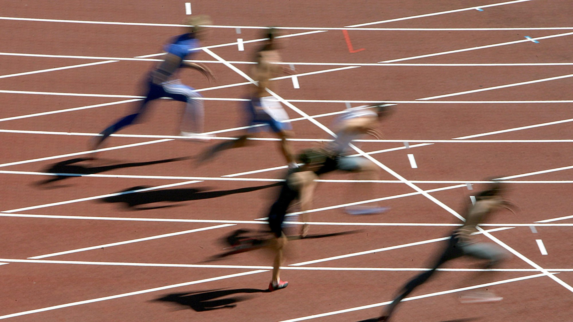 Sportler auf der Laufbahn im Stadion.