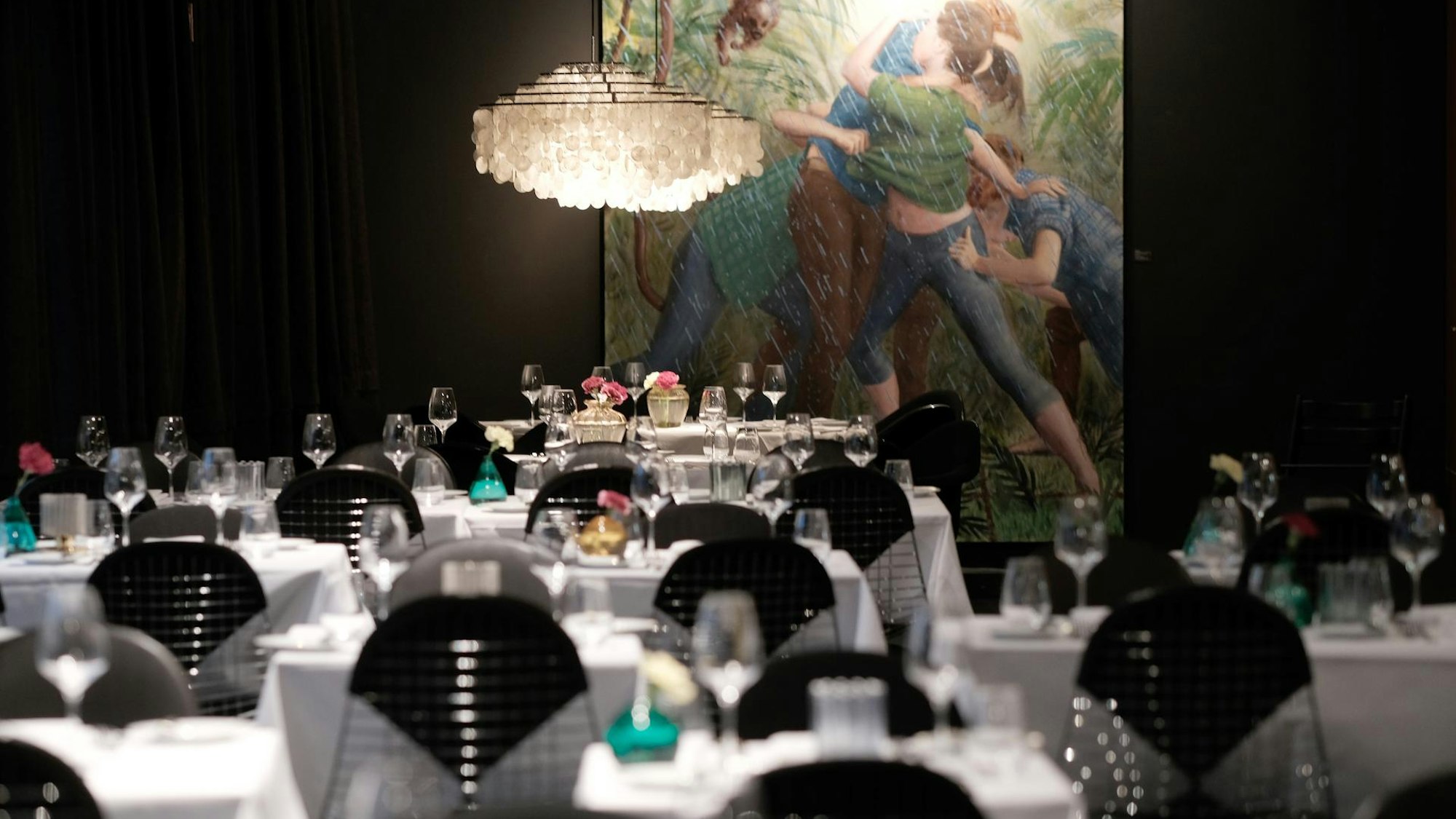 Edel gedeckte Tische, im Hintergrund ein großes Gemälde