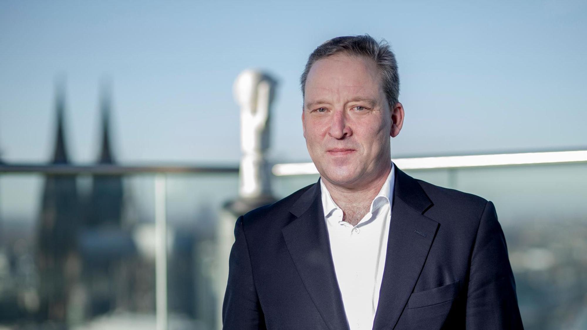 Matthias Zachert, Chef von Lanxess, steht auf der Dachterrasse der Kölner Konzernzentrale, im Hintergrund ist der Kölner Dom zu sehen.