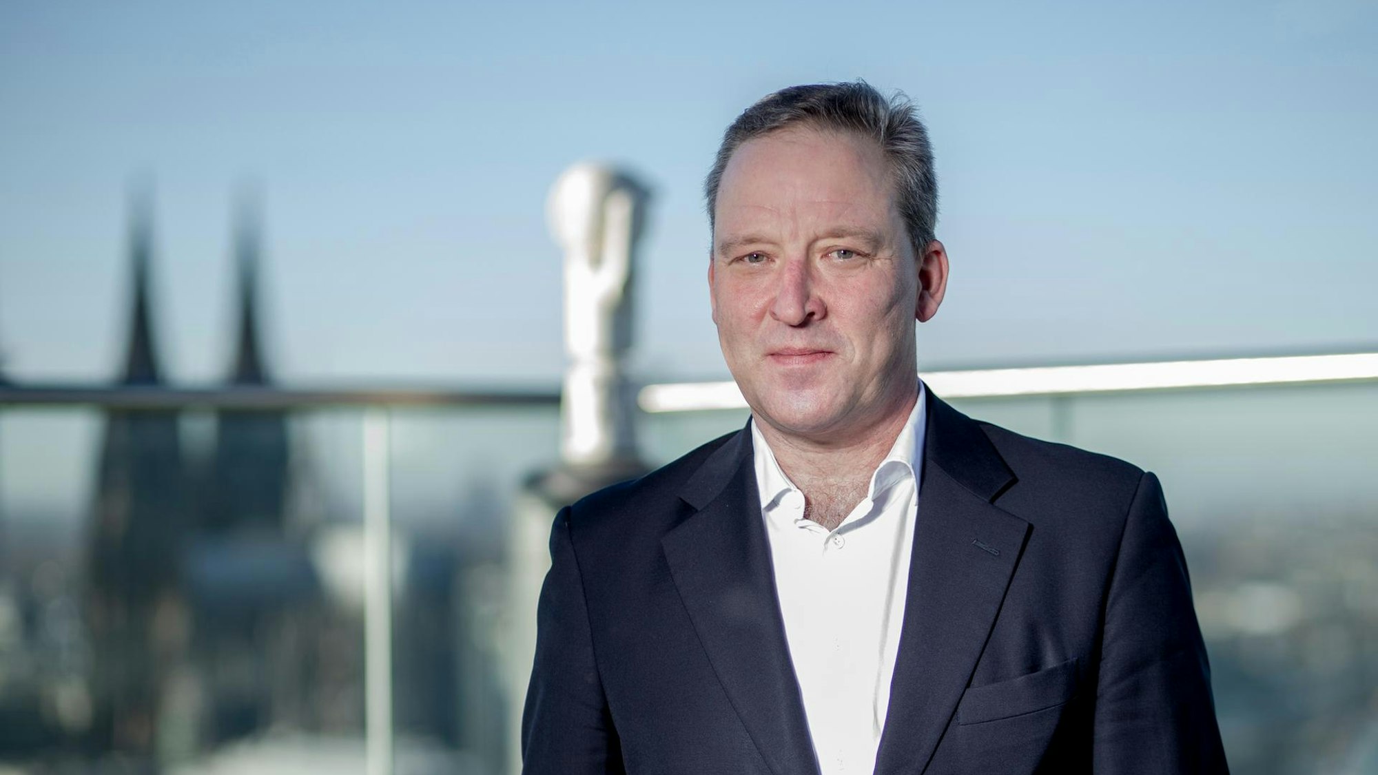 Matthias Zachert, Chef von Lanxess, steht auf der Dachterrasse der Kölner Konzernzentrale, im Hintergrund ist der Kölner Dom zu sehen.