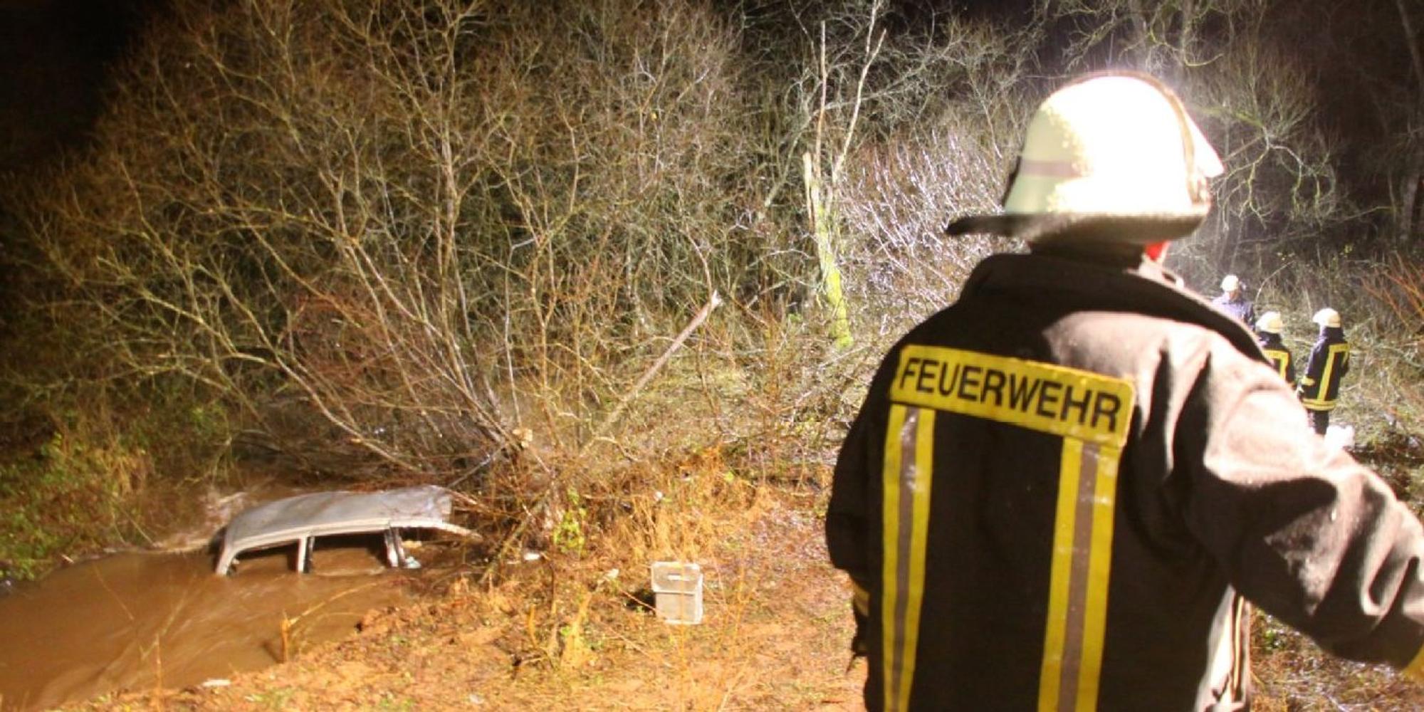Feuerwehrleute vor einem Gebüsch