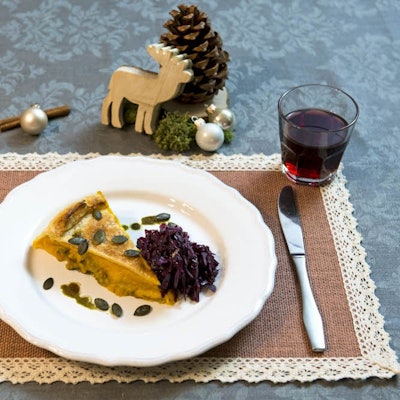 Ein Stück Kürbispastete mit Rotkohl liegt auf einem Teller.