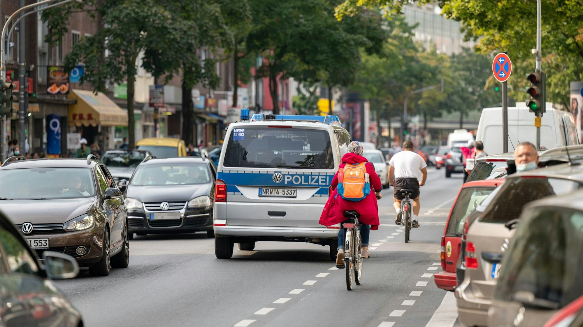 Auf der Hauptstraße sind viele Autos und Radfahrer unterwegs.