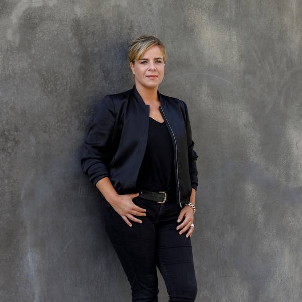 Die Grünen-Politikerin Mona Neubaur lehnt an einer Wand