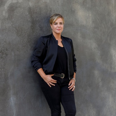 Die Grünen-Politikerin Mona Neubaur lehnt an einer Wand