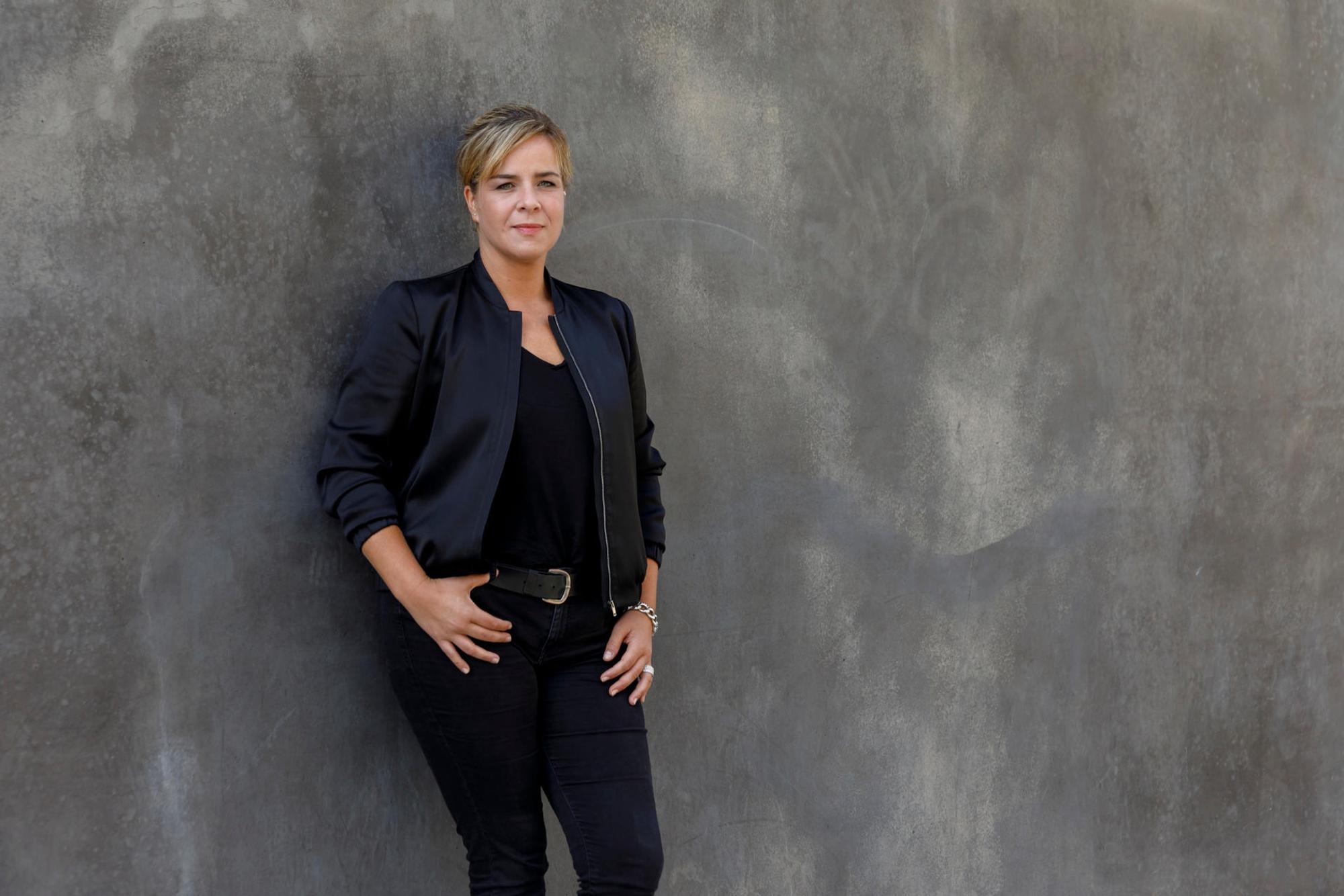 Die Grünen-Politikerin Mona Neubaur lehnt an einer Wand