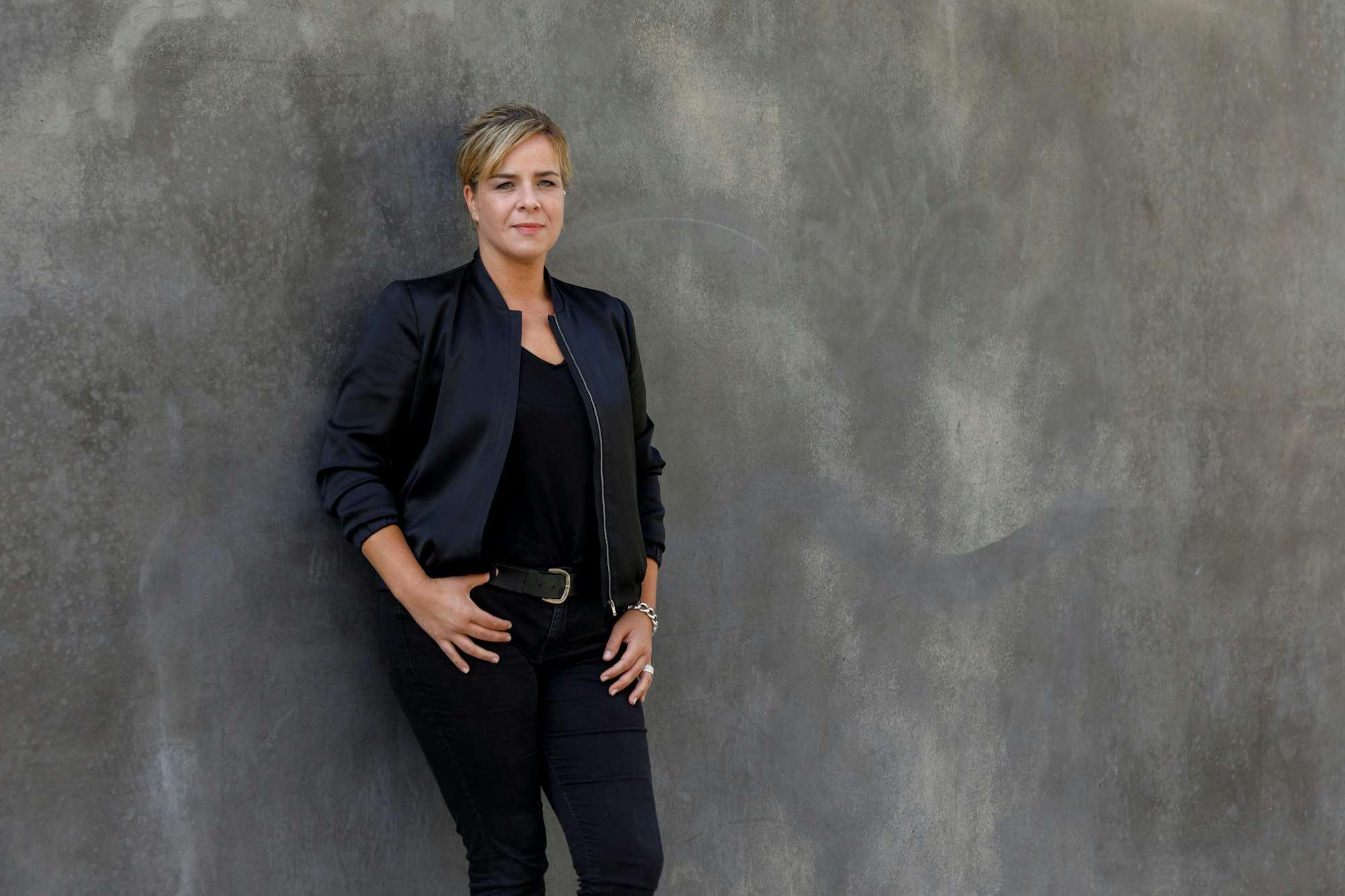 Die Grünen-Politikerin Mona Neubaur lehnt an einer Wand