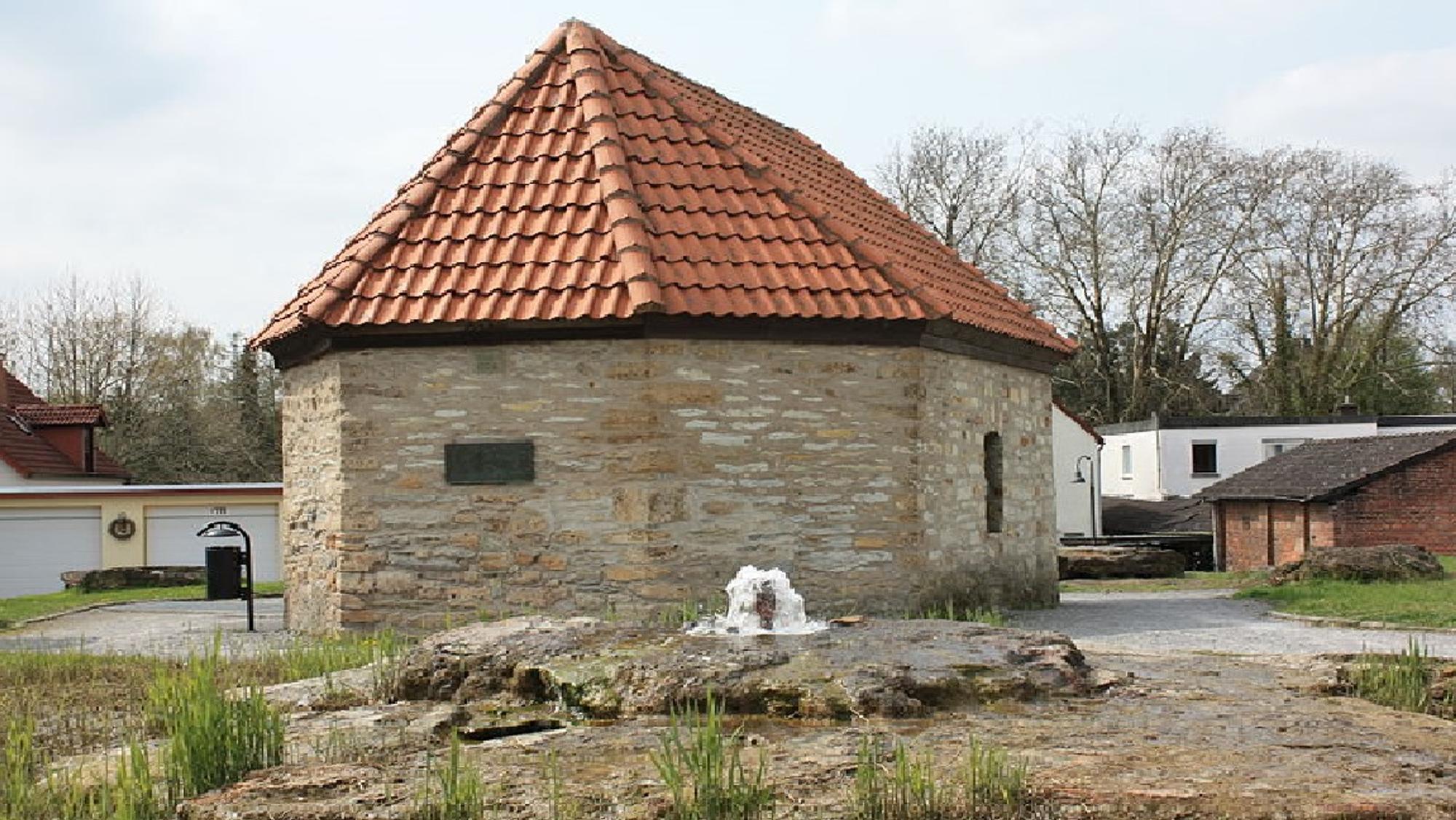 Kleines Gebäude aus Sandstein mit roten Dachziegeln.