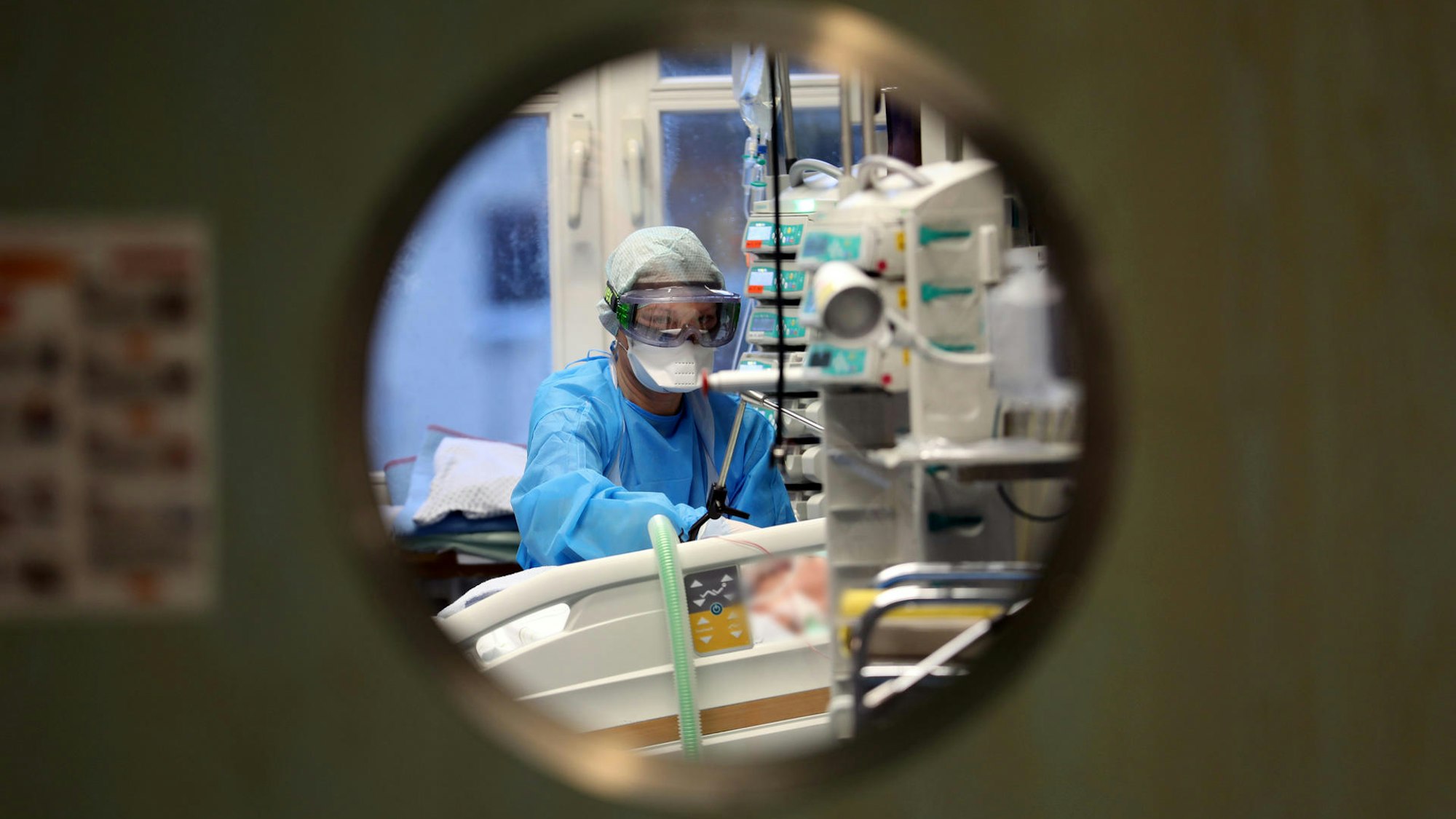 Ein Pfleger kümmert sich auf einer Intensivstation um einen Patienten.