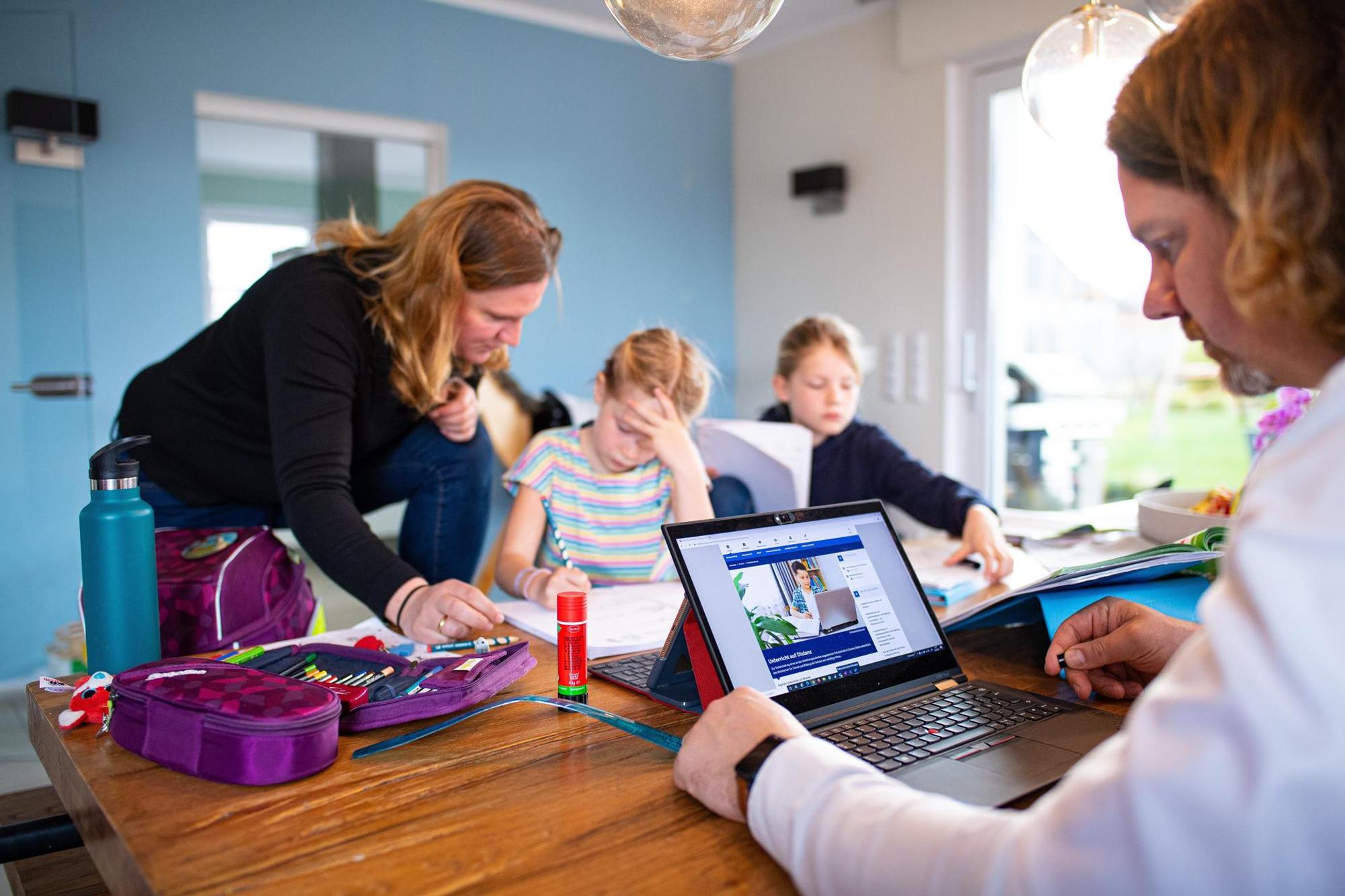 Schüler sitzen am Tisch und machen ihre Hausaufgaben.