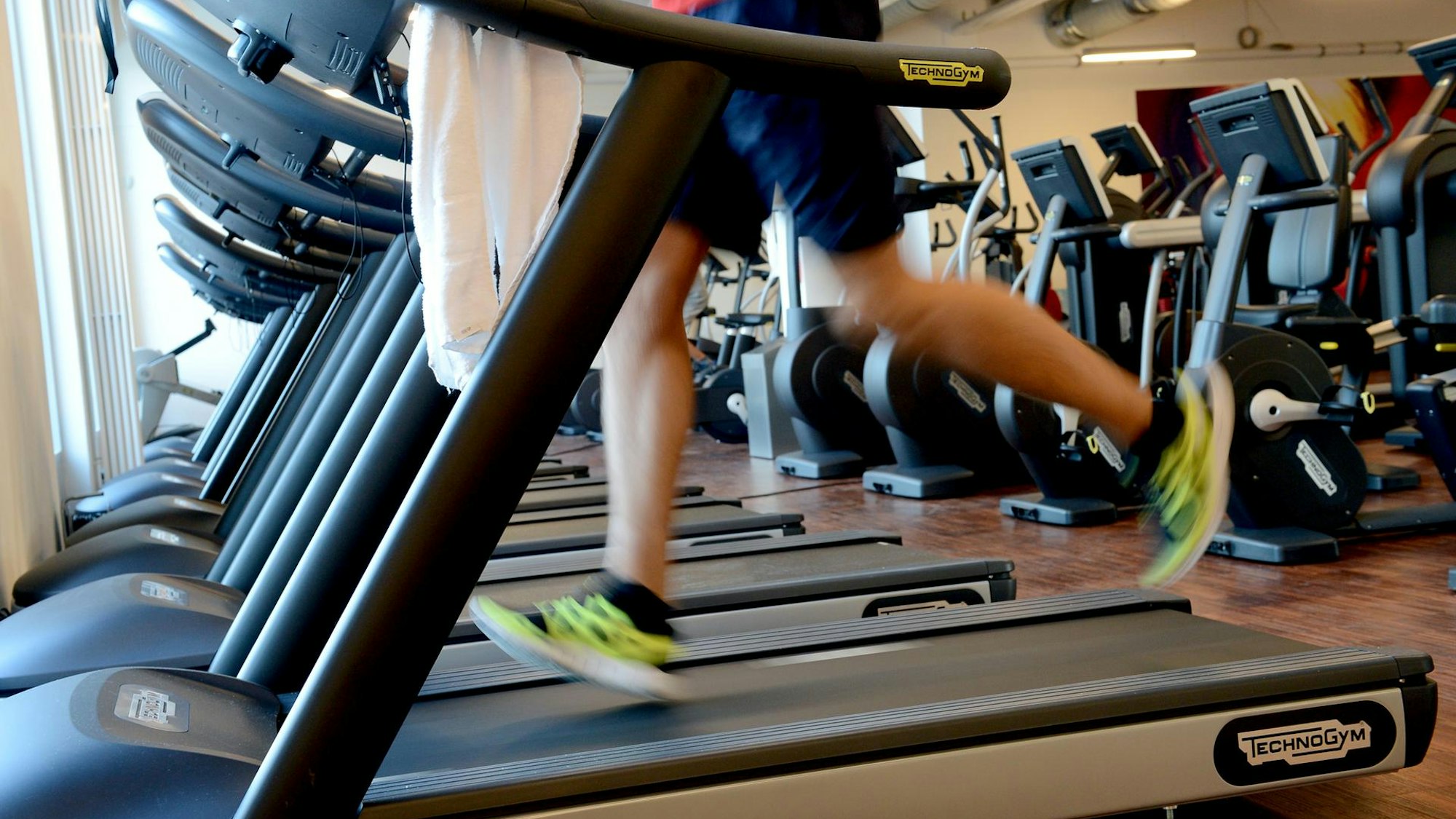 Eine Person läuft in einem Fitnessstudio auf einem Laufband.