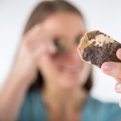 Frau legt sich Teebeutel auf die Augen