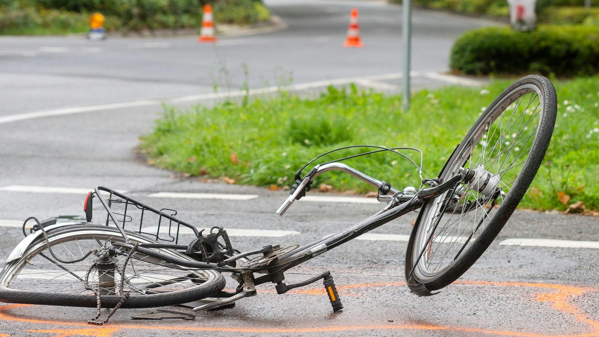 Das Bild zeigt ein Fahrrad nach einem Unfall auf einer Straße.