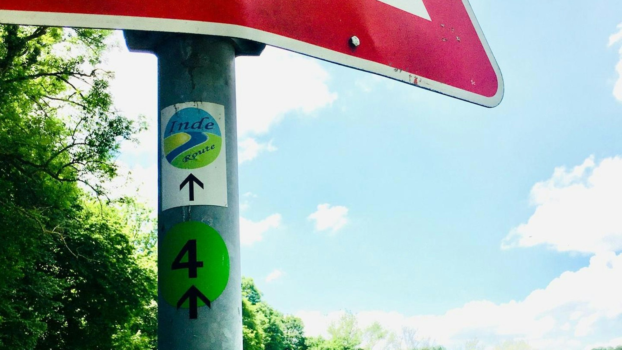 Das Logo der Inderoute auf dem Pfahl eines Schilds.