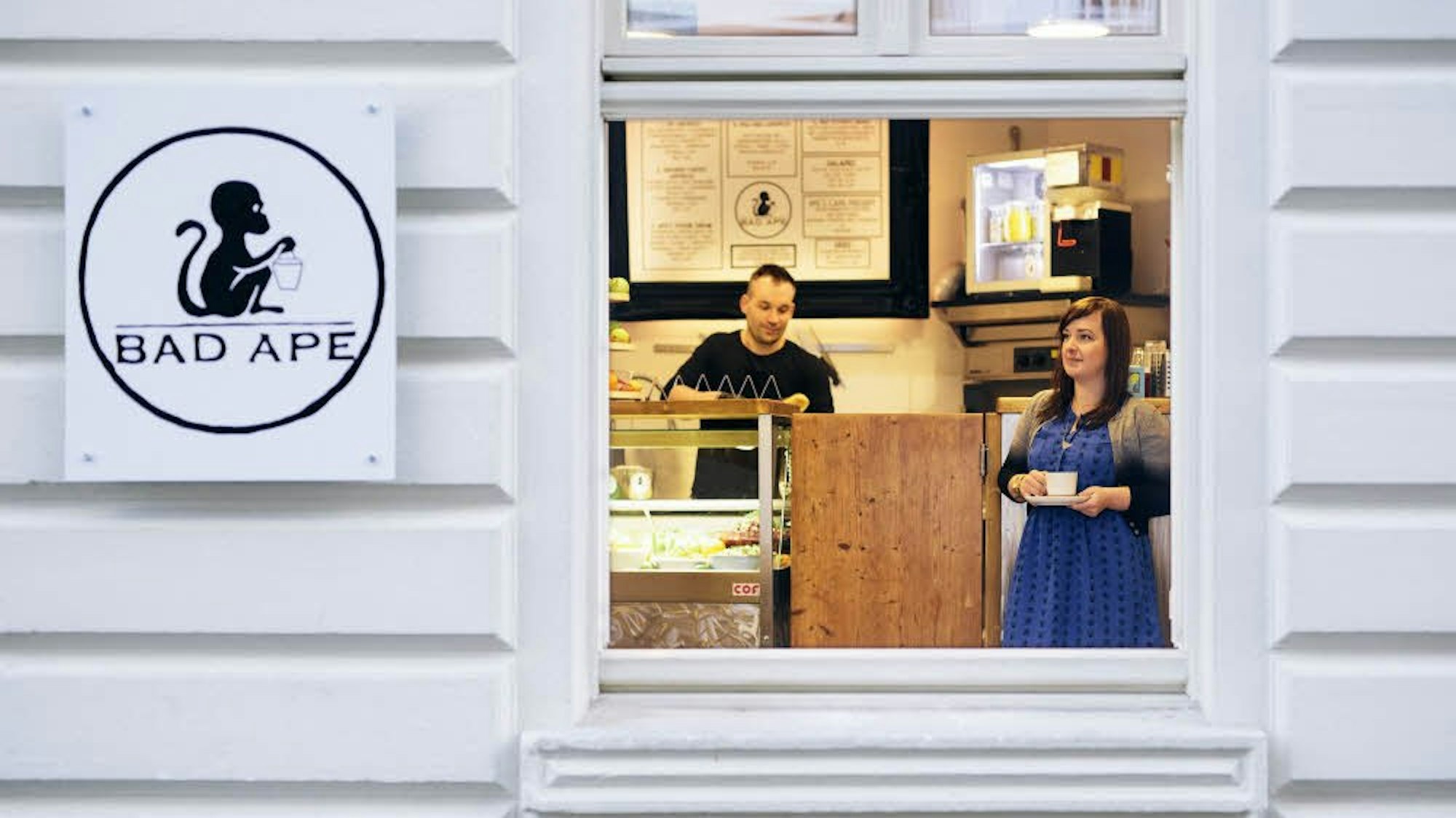 Blick von außen durch ein Fenstern in den Innenraum eines Cafés