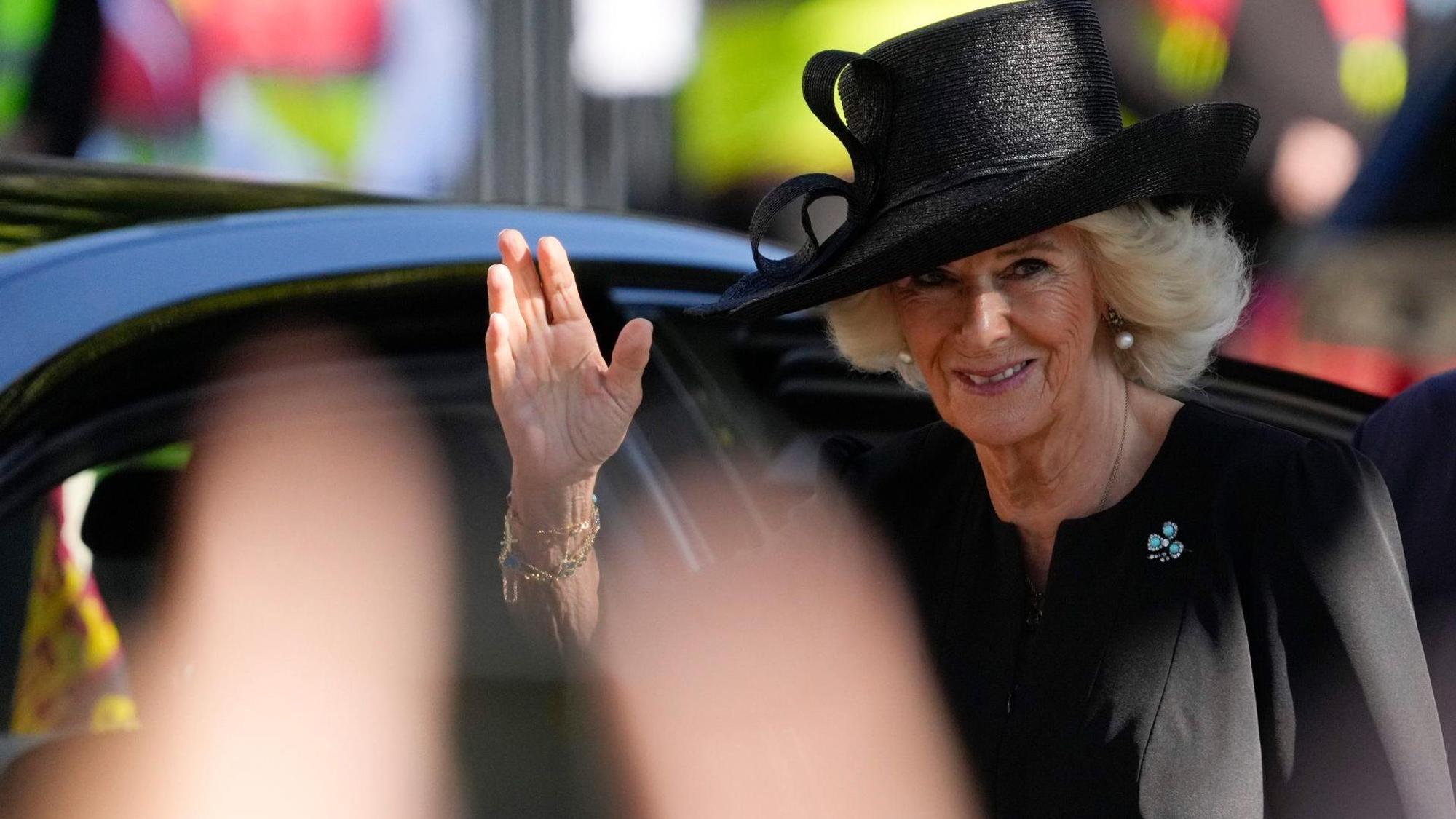 Königin Camilla winkt den Menschen zu.