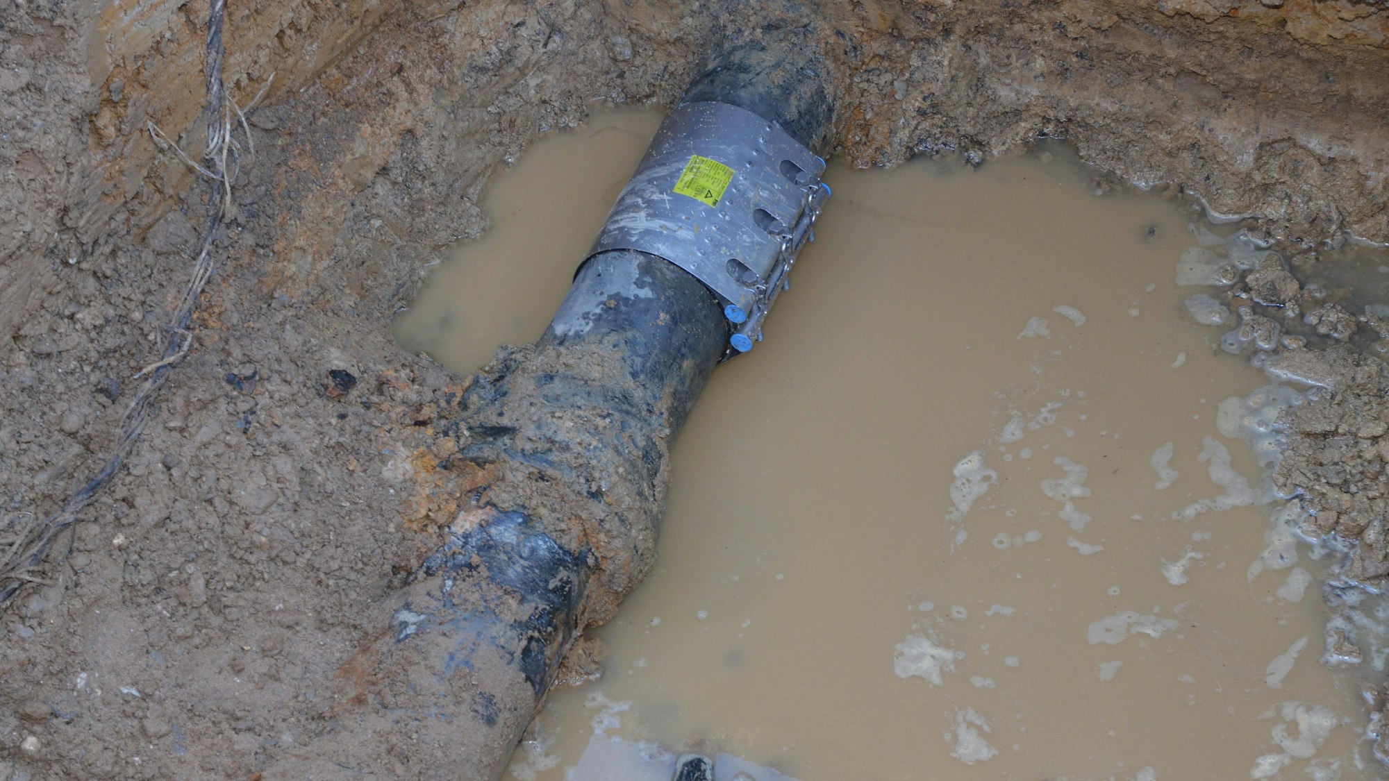 Ein Rohr liegt in Wasser und Schlamm (Archivbild).