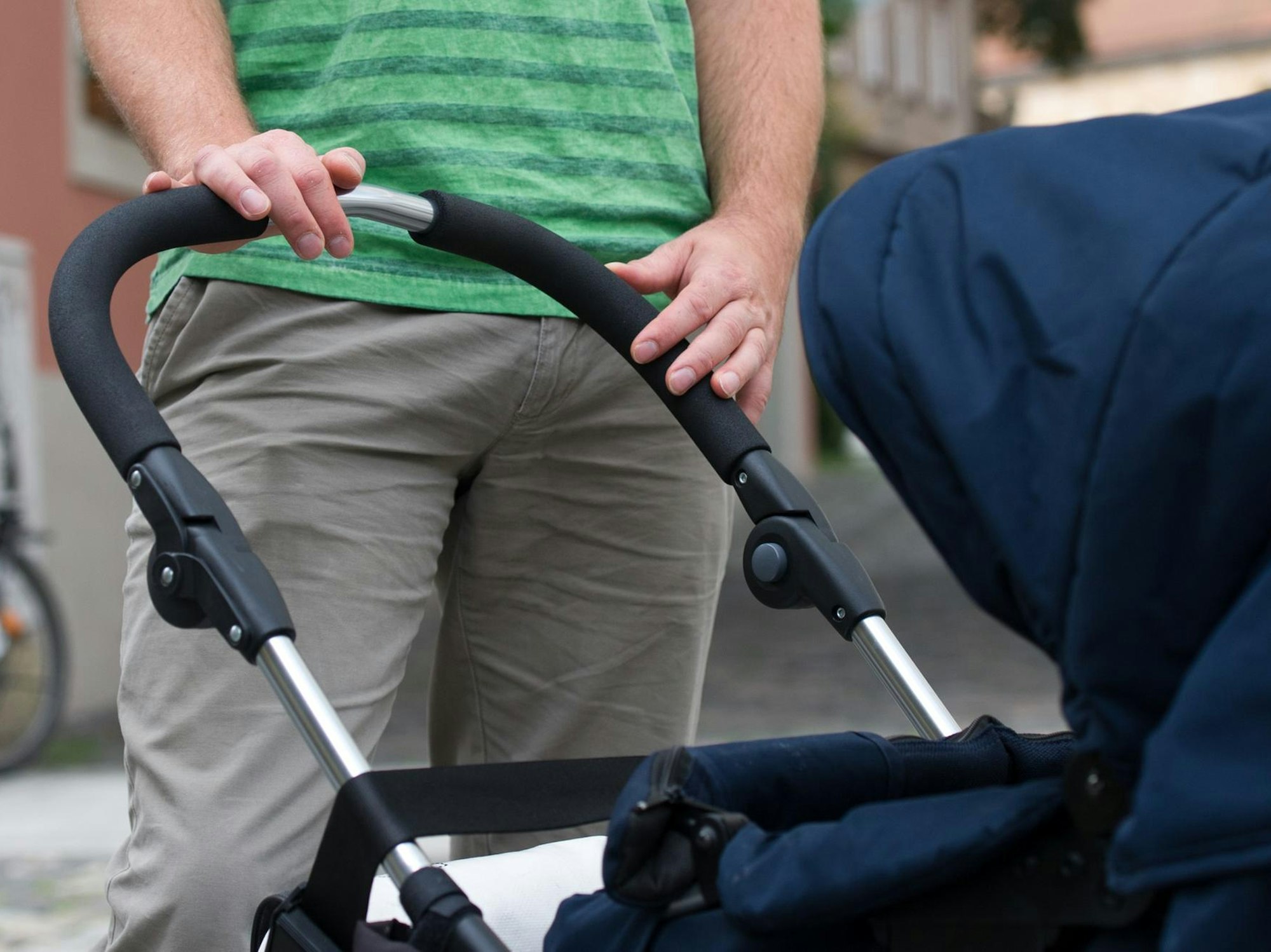 Mann schiebt Kinderwagen