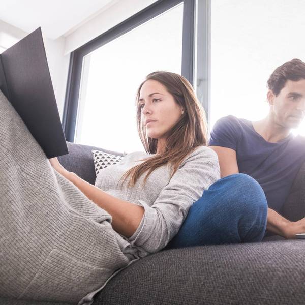 Mann_und_Frau_sitzen_mit_eigenem_Laptop_auf_dem_Sofa