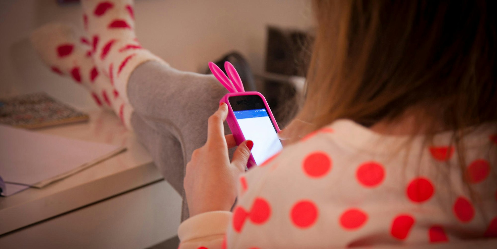 Ein Mädchen hält ein Handy in der Hand.