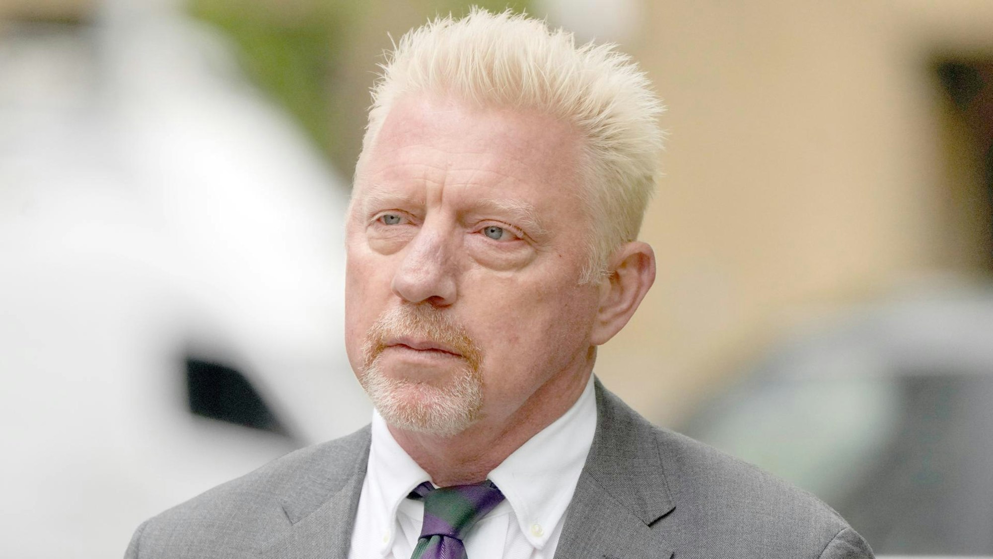 Boris Becker trägt Anyug und schaut an der Kamera vorbei.