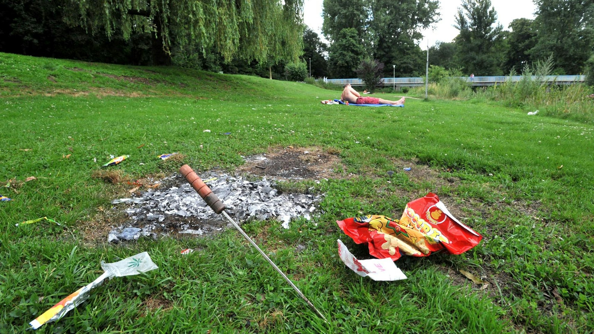 Verbrannter Rasen und Müll auf der Wupperwiese