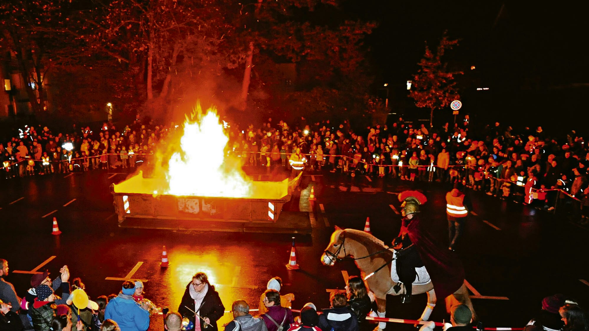 Ein Martinsfeuer. Am Rand stehen viele Menschen.