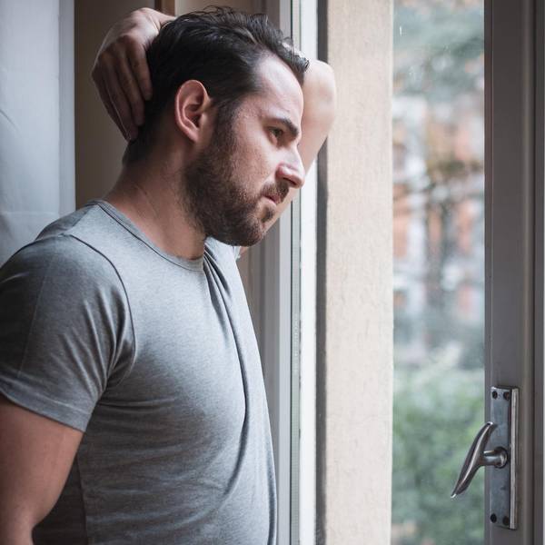 Mann steht an einem Fenster