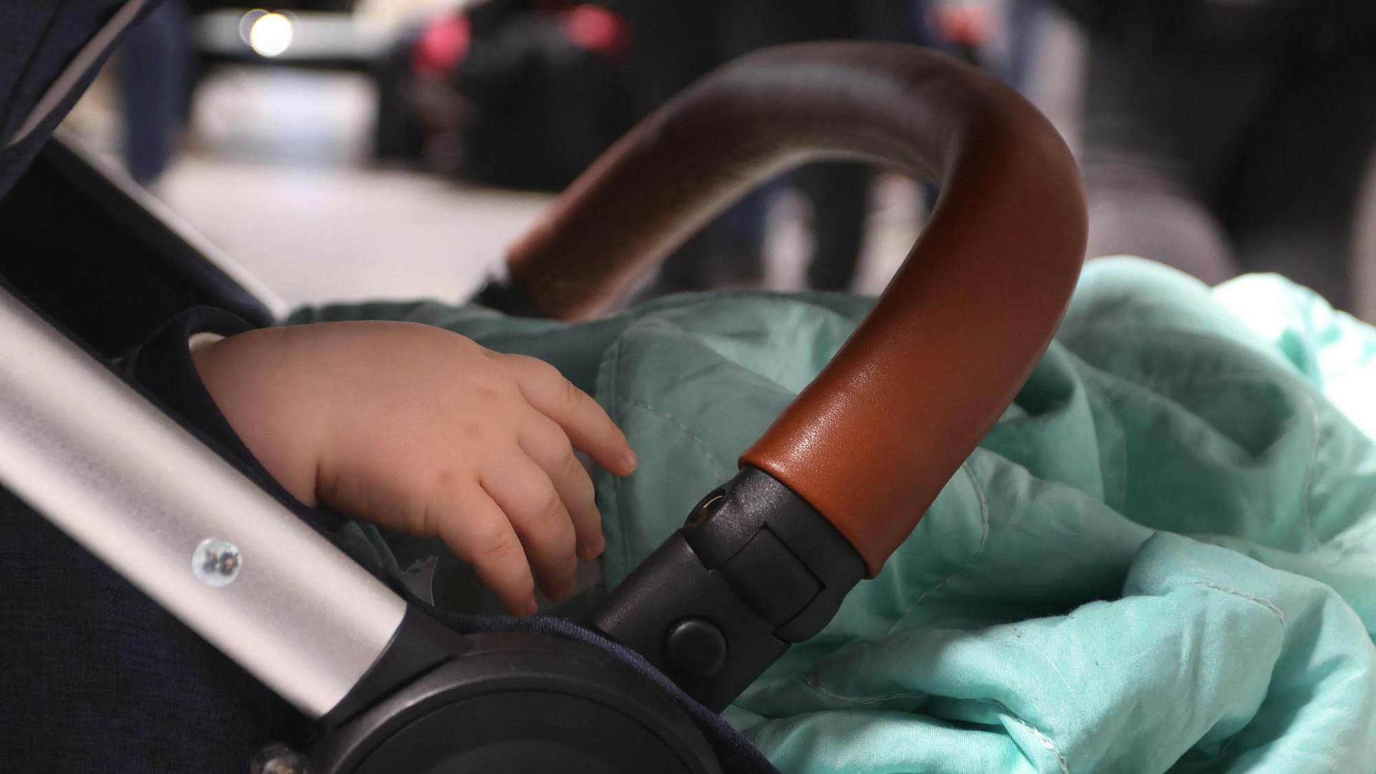 Ein Kind liegt in einem Kinderwagen.