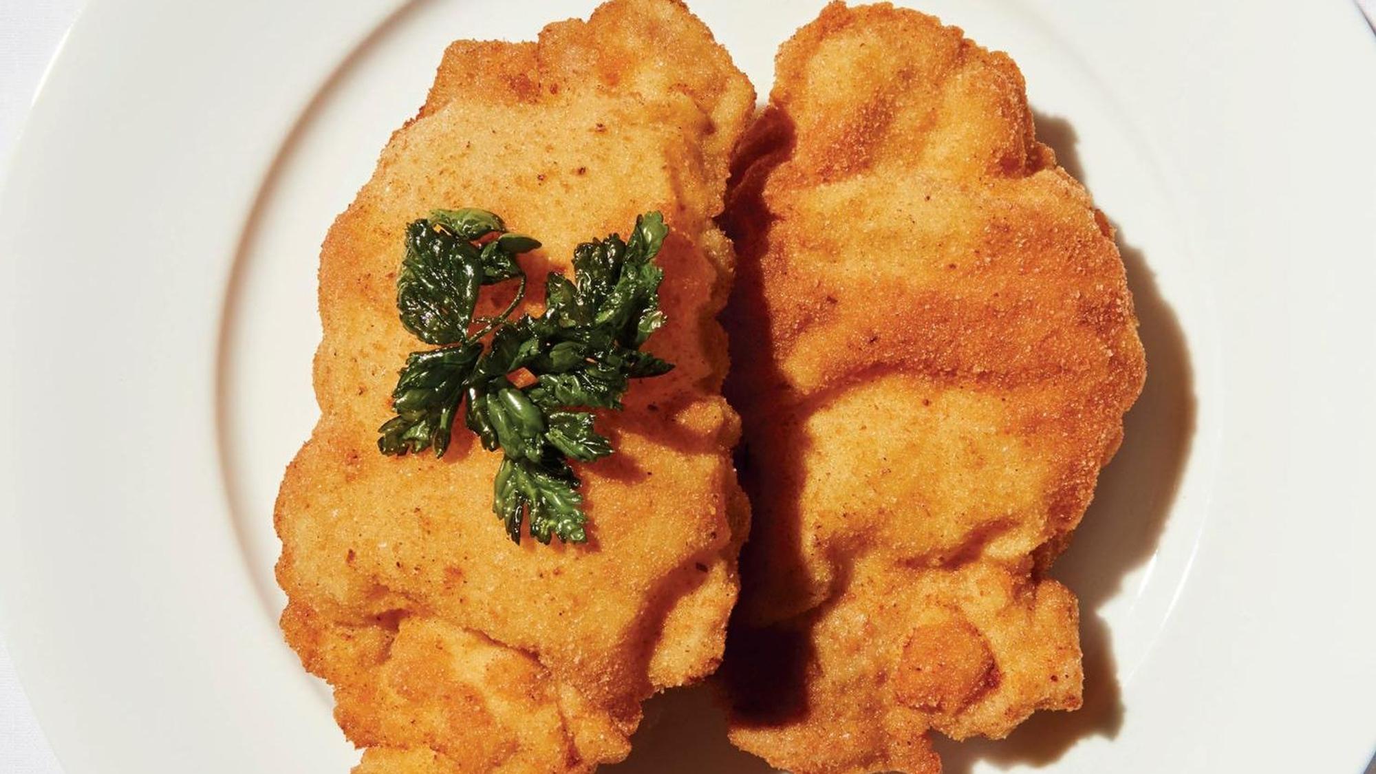 Zwei Wiener Schnitzel sind auf einem Teller angerichtet