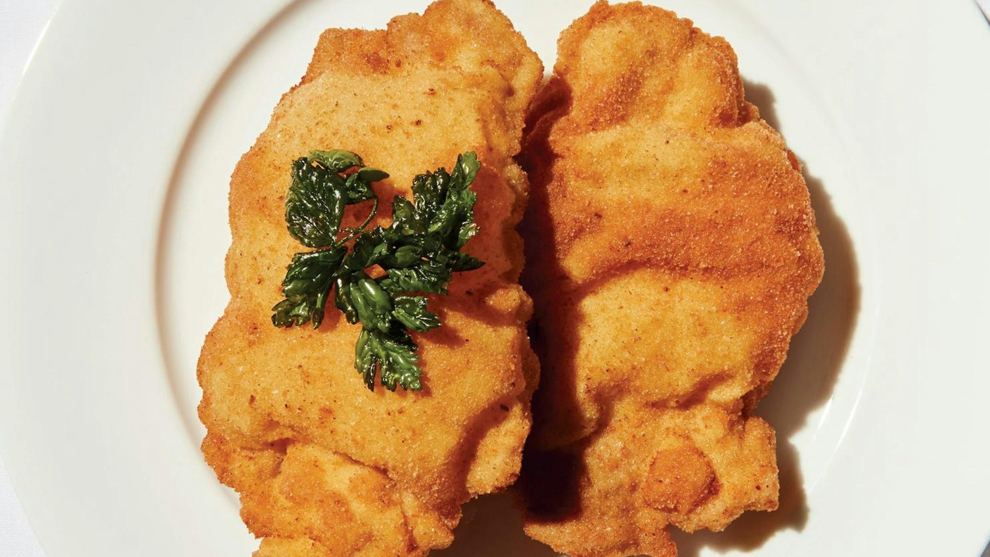 Zwei Wiener Schnitzel sind auf einem Teller angerichtet