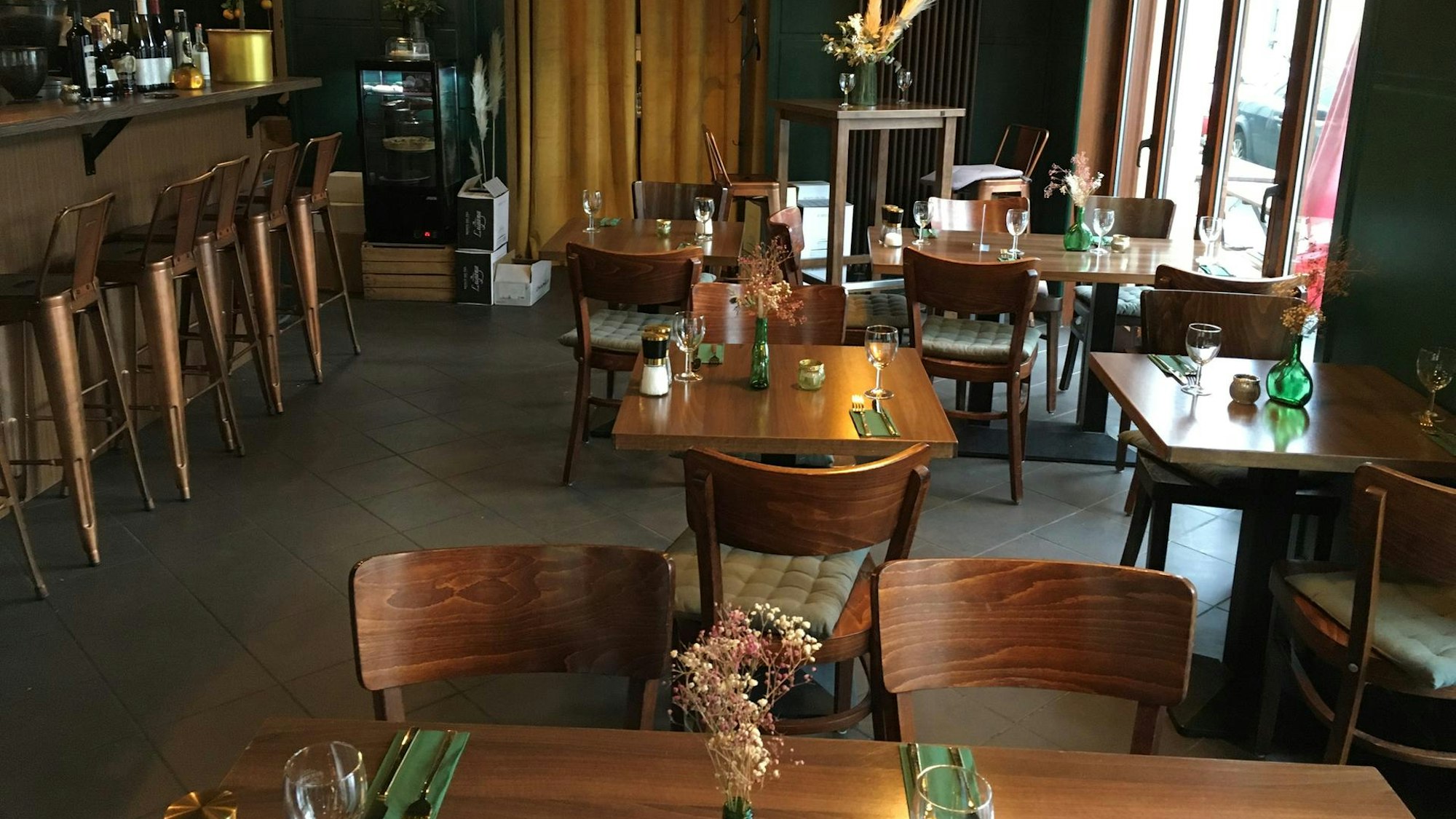 Gemütliches Weinlokal Jubo in Klettenberg mit Tischen und Stühlen aus Holz und einer langen Theke.