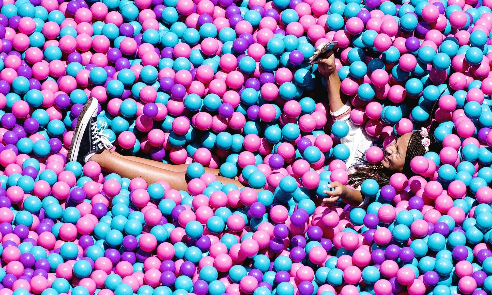 Junge Frau liegt im bunten Bällebad