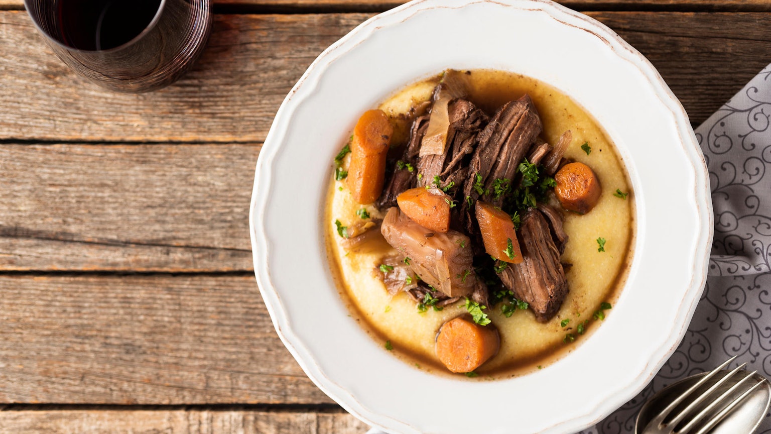 Ein Teller mit lecker angerichtetem Wildschweinfilet auf Polenta.