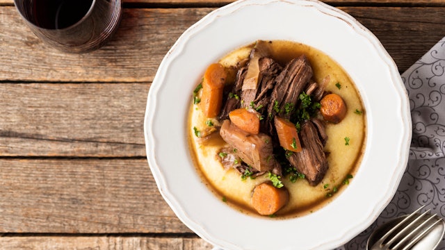 Ein Teller mit lecker angerichtetem Wildschweinfilet auf Polenta.