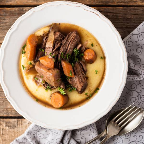 Ein Teller mit lecker angerichtetem Wildschweinfilet auf Polenta.