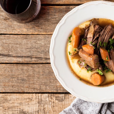 Ein Teller mit lecker angerichtetem Wildschweinfilet auf Polenta.