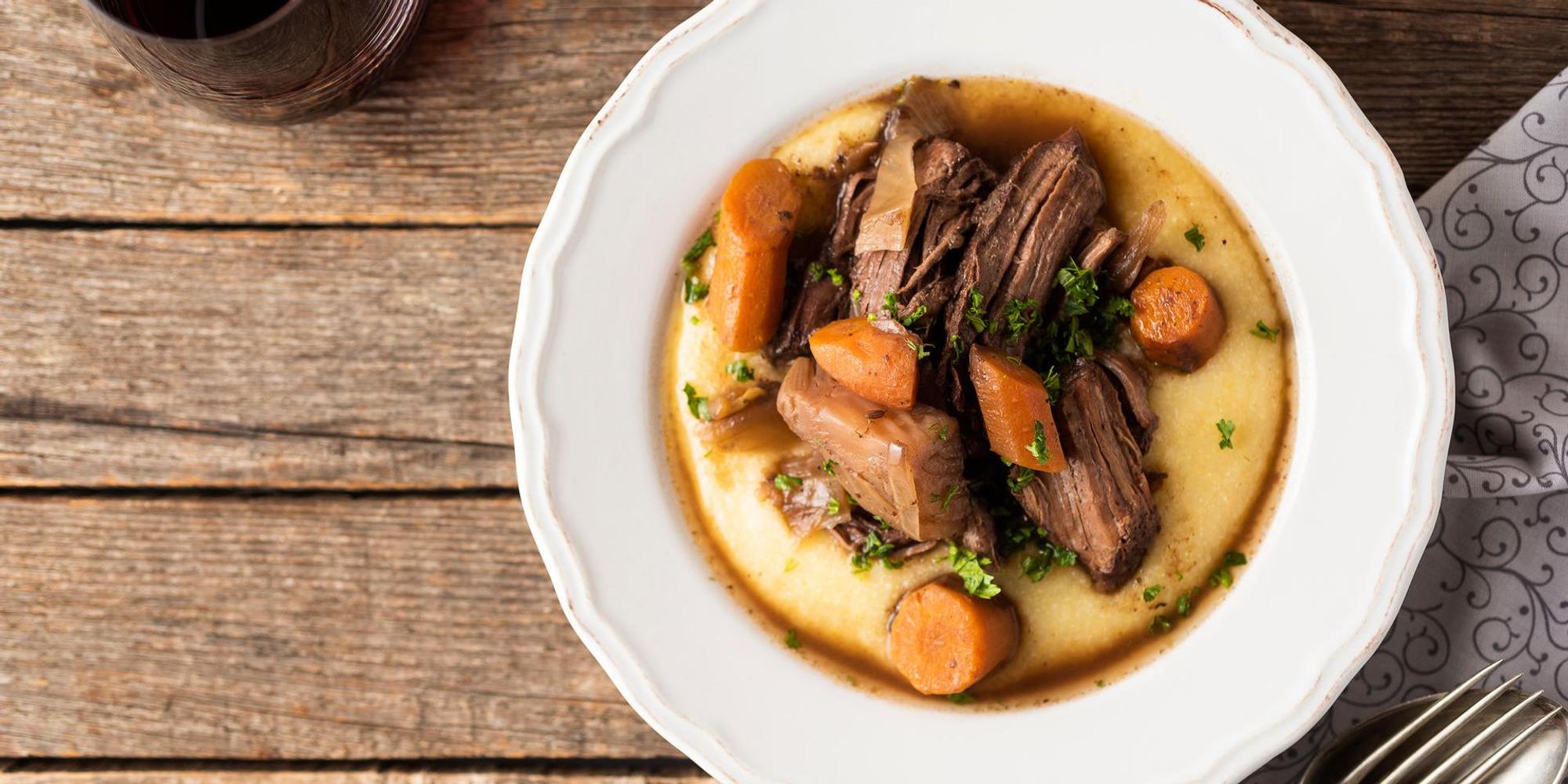 Ein Teller mit lecker angerichtetem Wildschweinfilet auf Polenta.