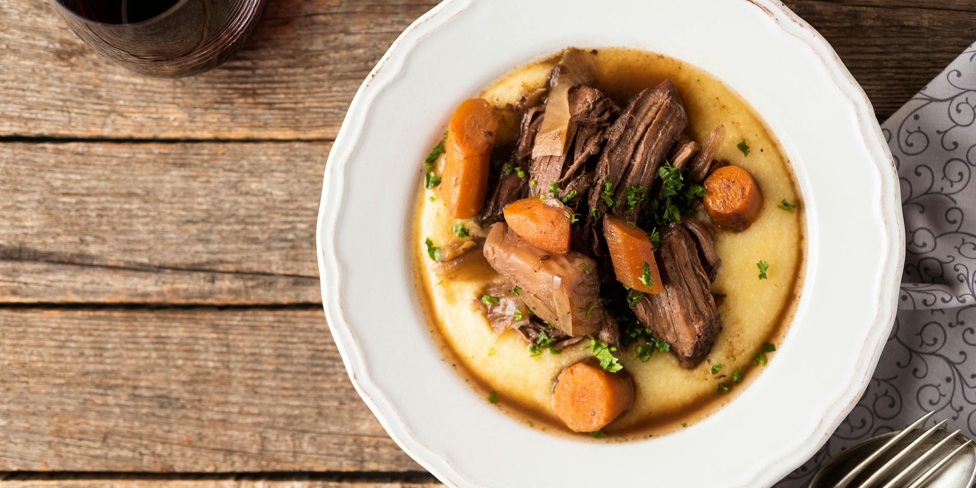 Ein Teller mit lecker angerichtetem Wildschweinfilet auf Polenta.