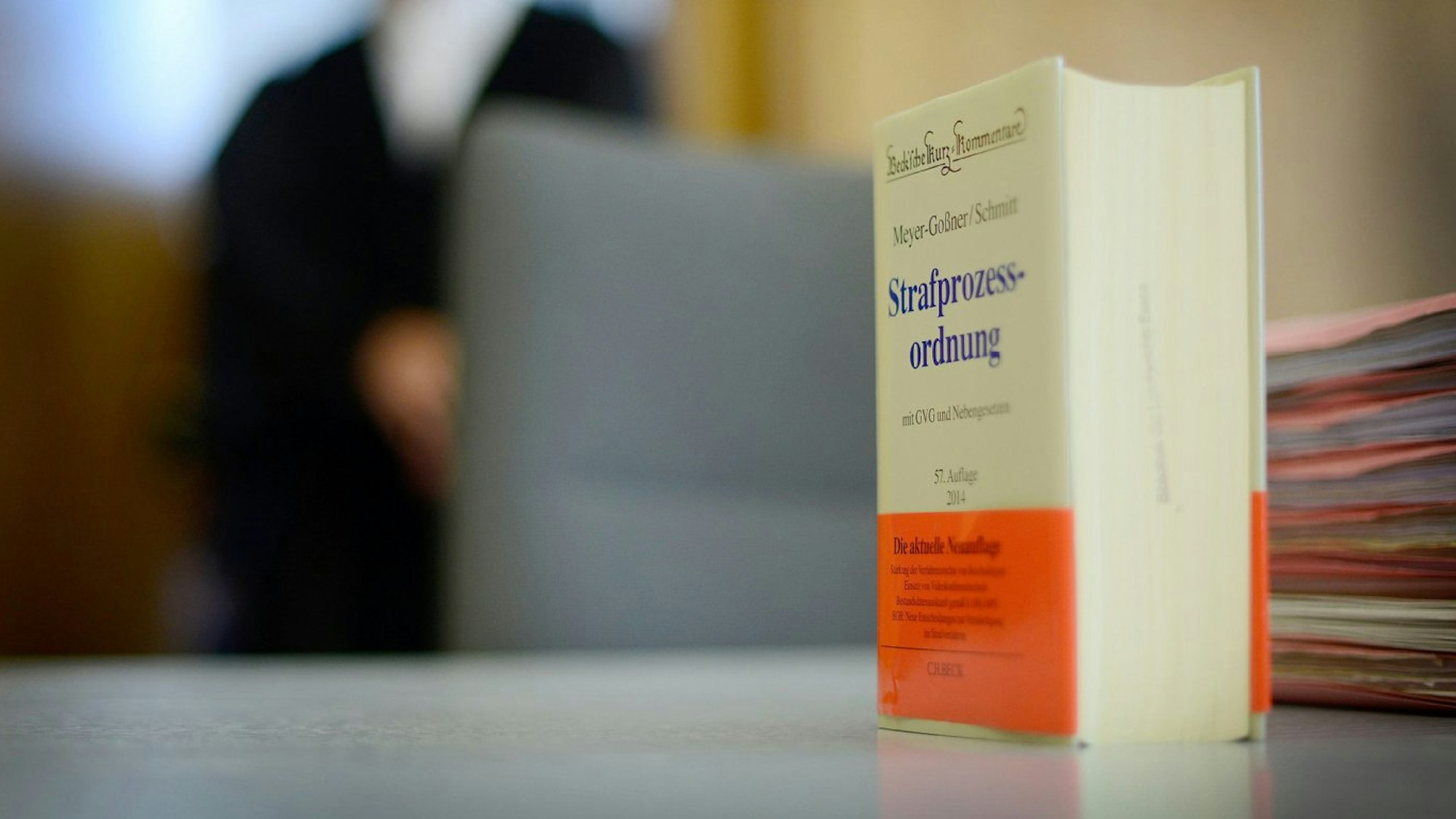 Ein Buch der Strafprozessordnung steht auf einem Verhandlungstisch.