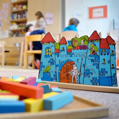 Das Foto zeigt Spielzeug in einem Kindergarten und mehrere Kinder.