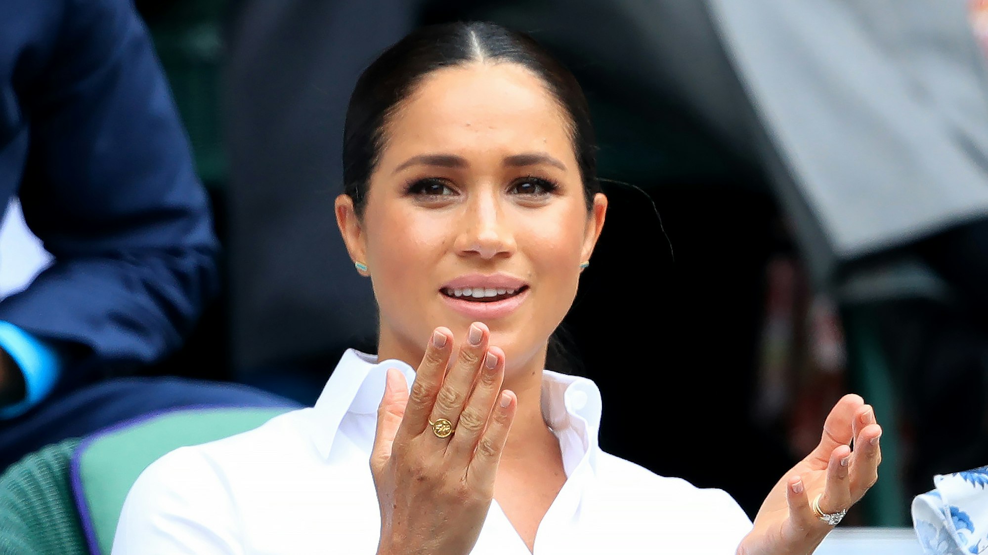 Meghan Markle hebt die Hände.