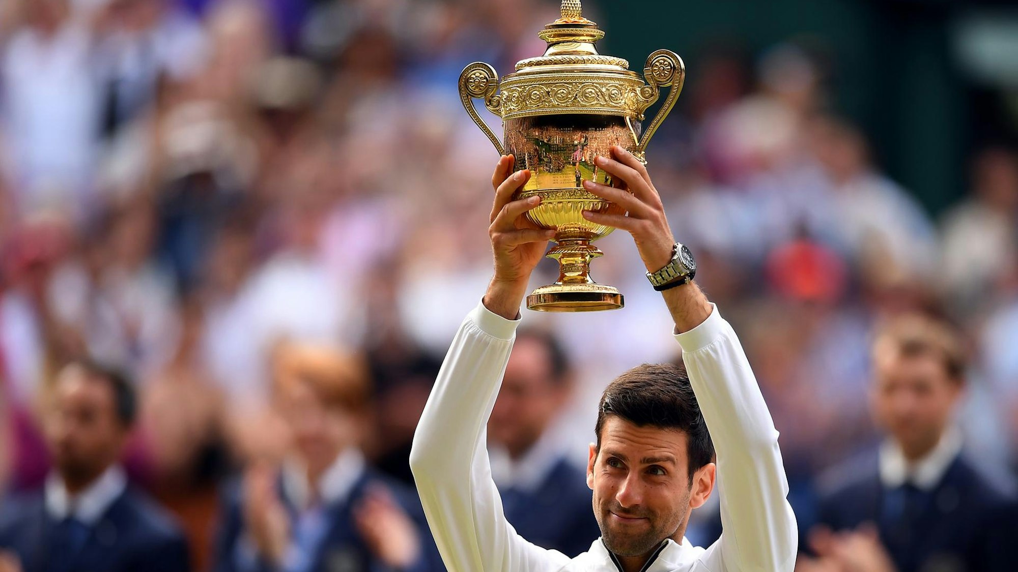Novak Djokovic hält Wimbledon-Trophäe hoch.