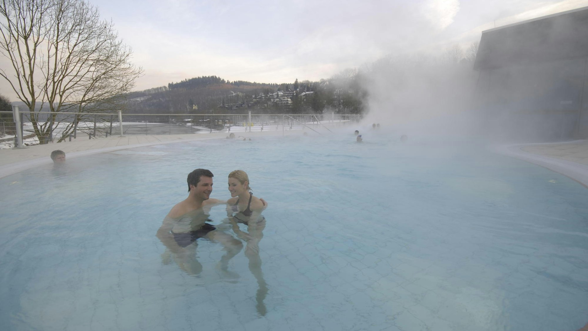 Pärchen in einem dampfenden Schwimmbecken.