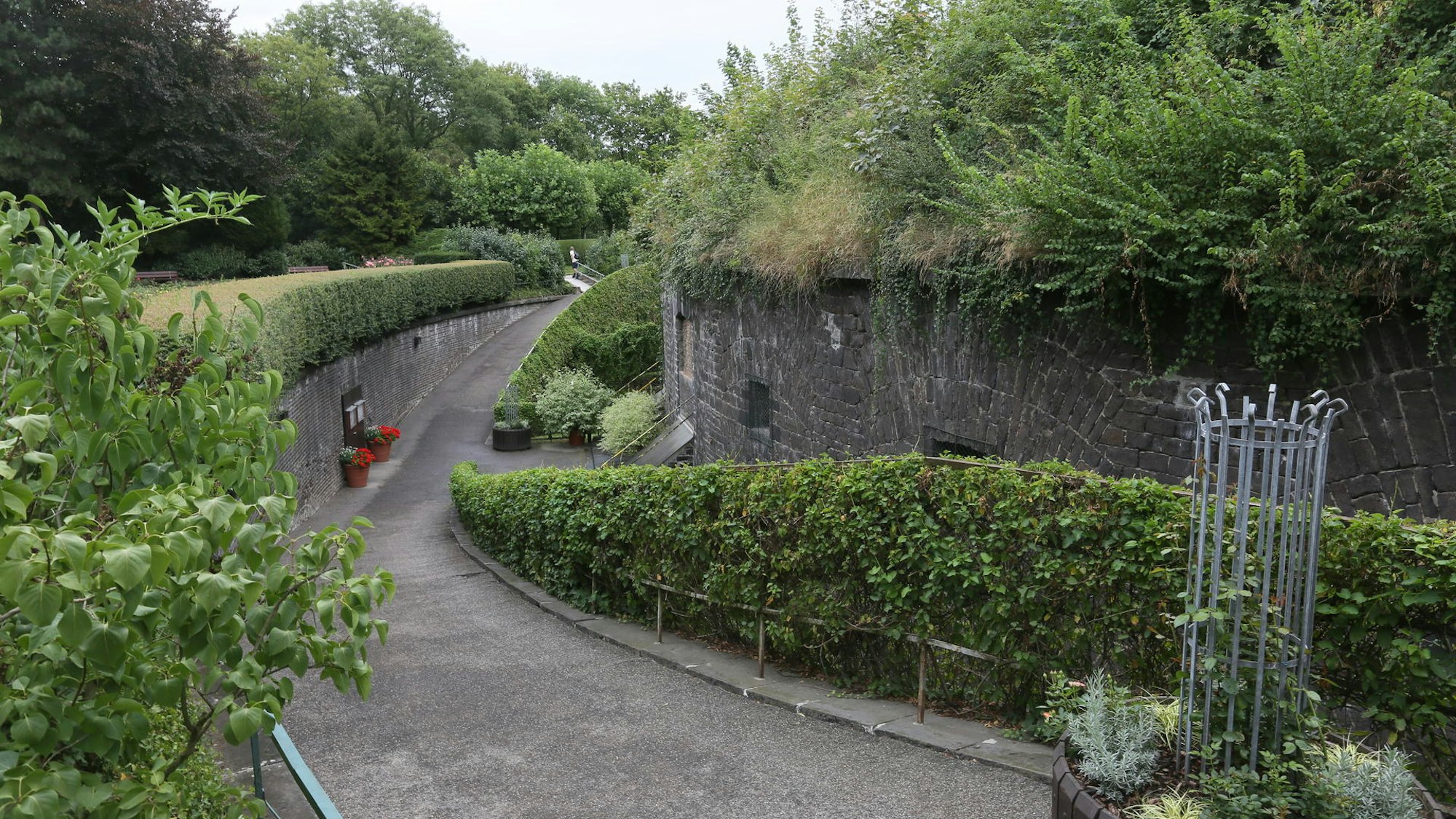 ein Weg führt an einer alten Mauer vorbei