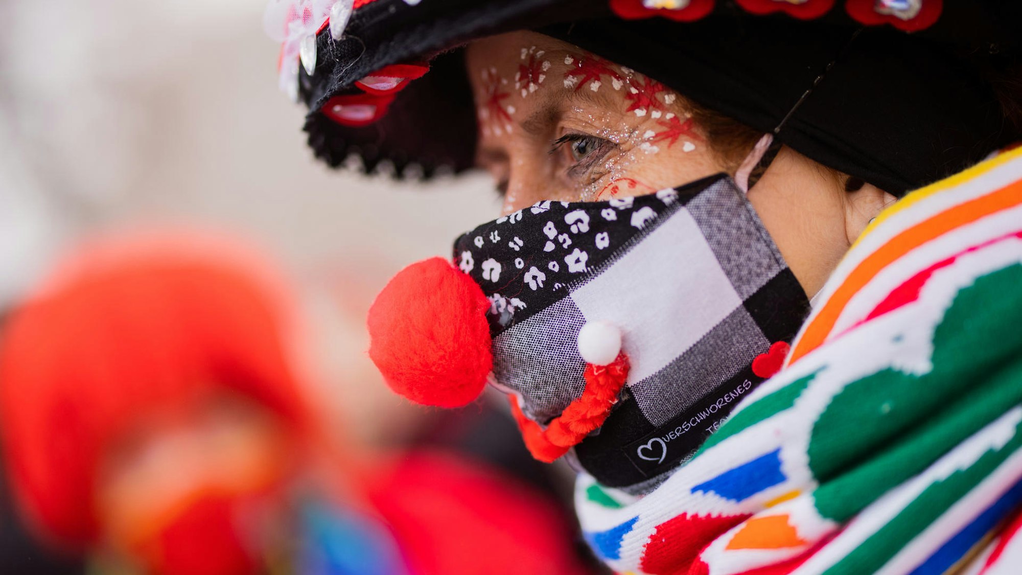 Eine Jeckin feiert mit medizinischer Maske und Kostüm.