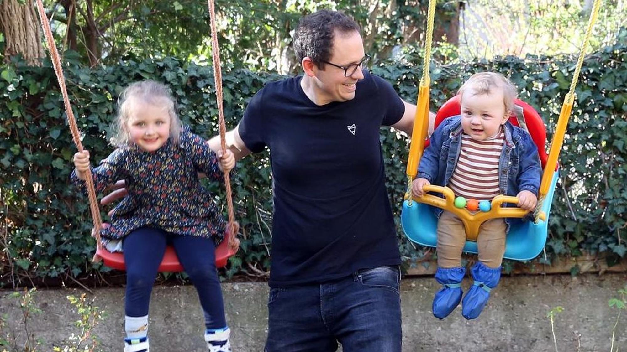 Simon Hölzemann schubst seine Kinder auf der Schaukel an.