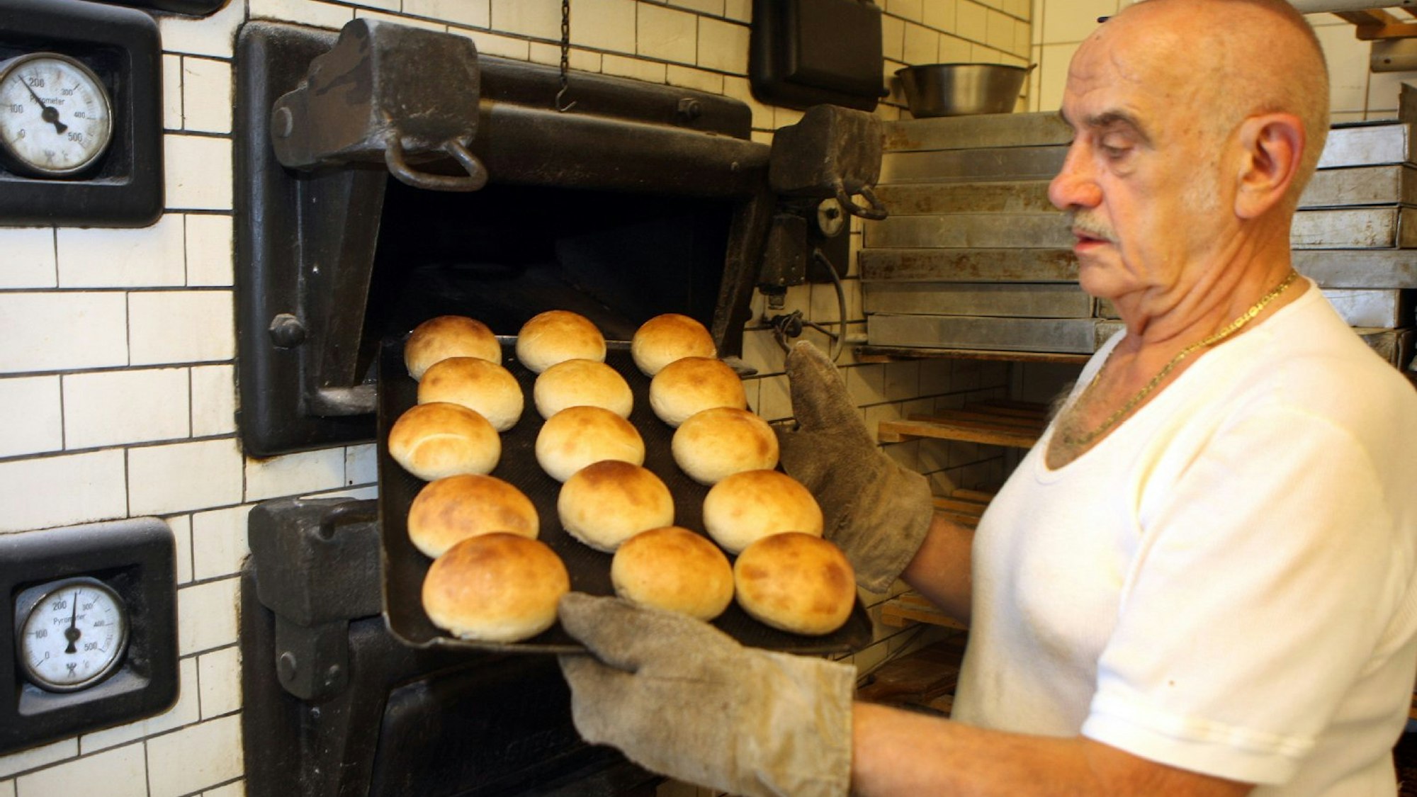 Gold gebackene Brötchen werden aus dem Ofen der Backstube geholt.