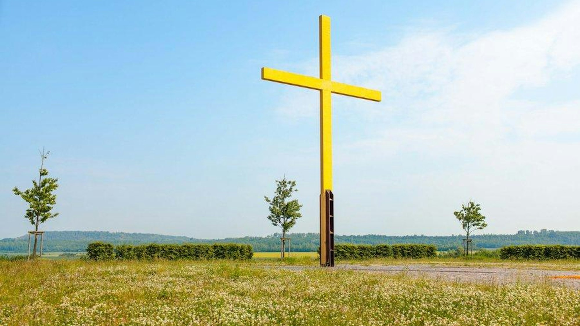 Gelbes Gipfelkreuz auf einer weiten Weise